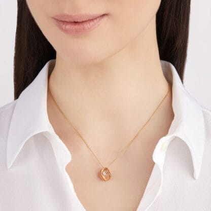 Velaa Star Pendant in 18k Rose Champagne Gold. on the model